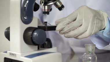 Kimyasal maddeyi mikroskopla analiz eden bilim adamlarına yaklaş.