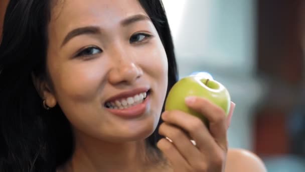有機野菜の新鮮なリンゴを手にした若い魅力的なアジアの女性のクローズアップとカメラで笑顔が元気に — ストック動画