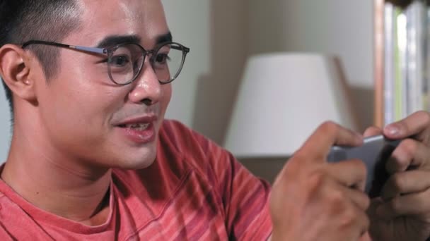 Close Ung Asiatisk Mand Der Holder Smartphone Hænderne Skriver Griner – Stock-video