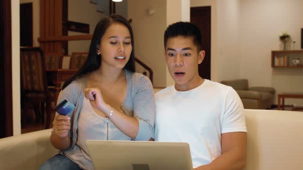 Молодая Азиатская Пара Сидит Дома Диване Смотрит Ноутбук Выбирая Одежду — стоковое видео