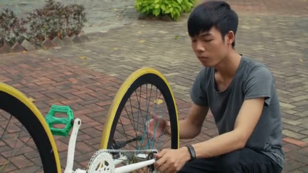 Střední Záběr Mladý Asijský Muž Sedí Zpevněné Silnici Snaží Opravit — Stock video