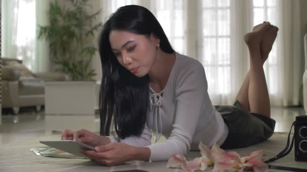 타블렛을 바닥에 아시아 여성의 페이지를 넘기는 카메라를 — 비디오