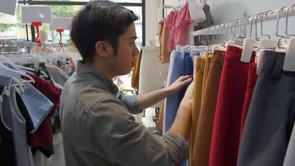 Média Tiro Jovem Homem Asiático Procura Roupas Loja — Vídeo de Stock