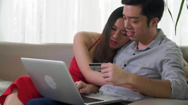 Średnie Ujęcie Azjaty Siedzącego Kanapie Laptopem Mężczyzny Piszącego Informacje Karty — Wideo stockowe
