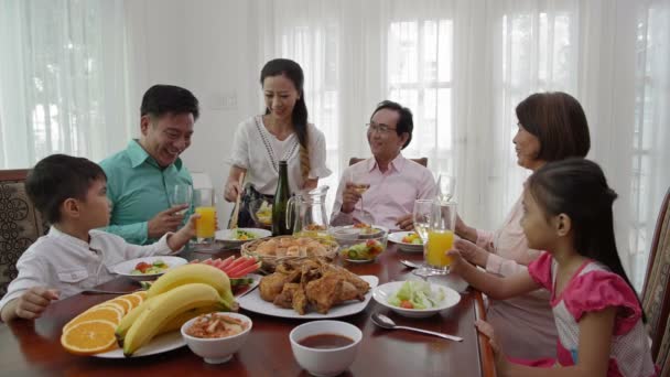 Fechamento Família Asiática Reunida Mesa Jantar Enquanto Mulher Com Prato — Vídeo de Stock