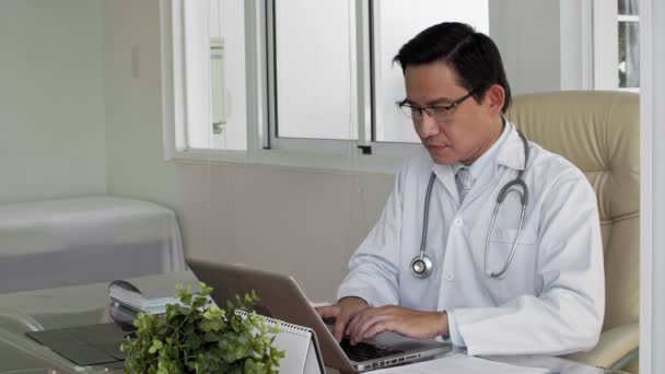 Азиатский Врач Среднего Возраста Работающий Ноутбуком Изучающий Рентгенограмму Пациента Делающий — стоковое видео