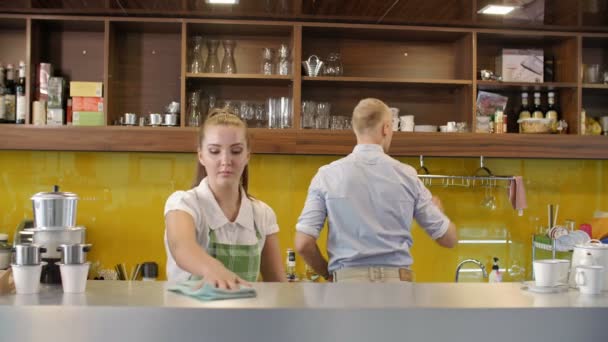 Medium Shot Van Jonge Serveerster Voorgrond Vegen Glazen Schotels Met — Stockvideo