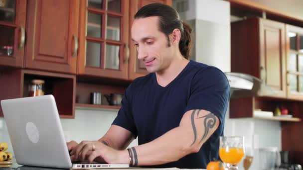 Kaukasier Sitzt Küche Vor Laptop Und Tippt Nachrichten — Stockvideo