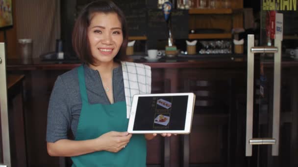 Atrakcyjna Właścicielka Kawiarni Azjatyckiej Fartuchu Trzymająca Cyfrowy Tablet Pokazująca Menu — Wideo stockowe