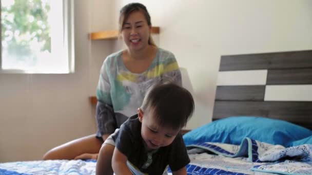 Jovem Mãe Asiática Alegre Sentando Seu Adorável Filho Cama Assistindo — Vídeo de Stock