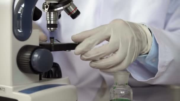 Close Pesquisador Analisando Gota Líquido Verde Com Microscópio — Vídeo de Stock