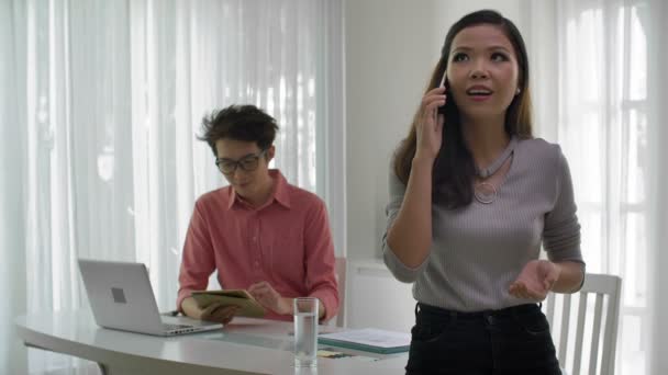 Medium Shot Young Asian Woman Standing Desk Talking Telephone While — Stock Video