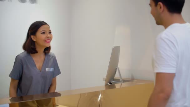 Medium Skott Asiatisk Receptionist Spa Center Hälsning Manlig Klient Och — Stockvideo