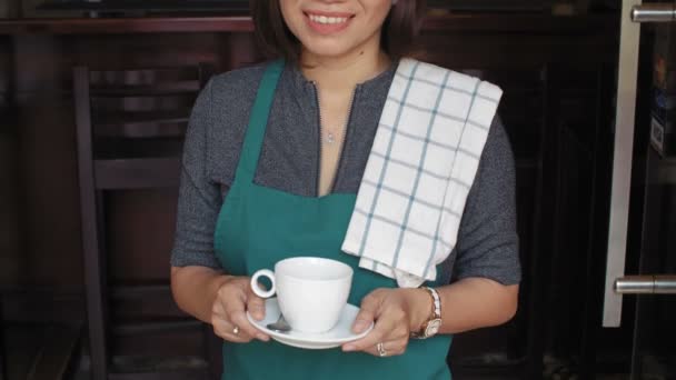 バーに立つ魅力的なアジアの女性バーテンダーのショットを傾け コーヒーを飲みながらカメラで微笑む陽気に — ストック動画