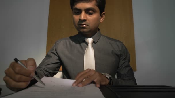 Zoom Out Ινδός Επιχειρηματίας Κάθεται Στην Επιφάνεια Εργασίας Διαβάζοντας Συμβόλαιο — Αρχείο Βίντεο