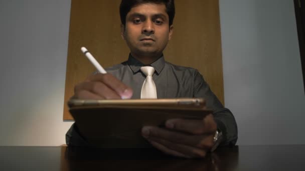 彼の手の中にタブレットやスタイラスを保持し 電子的に文書に署名し デスクトップに座ってインドのビジネスマンからズームアウト — ストック動画