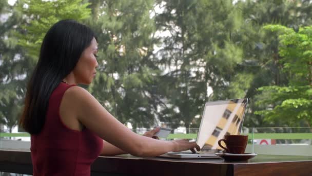 Блокировка Азиатской Женщины Сидящей Кафе Ноутбуком Печатающей Информацию Кредитной Карты — стоковое видео