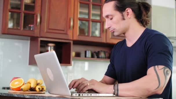 Kafkasyalı Adamın Mutfakta Oturup Dizüstü Bilgisayarda Klavyeyle Yazı Yazması Sonra — Stok video