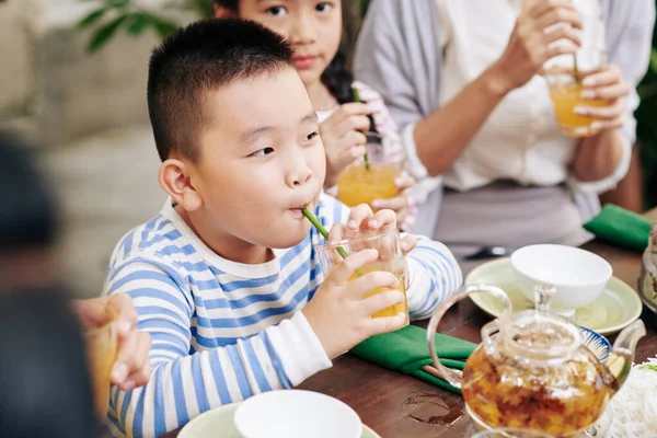 Schattig Klein Vietnamees Jongen Nippen Glas Sinaasappelsap Bij Familie Diner — Stockfoto