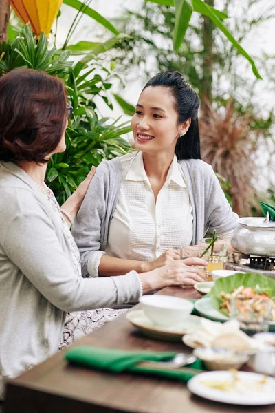 年轻美丽的越南女人和妈妈一起吃饭讨论新闻 — 图库照片