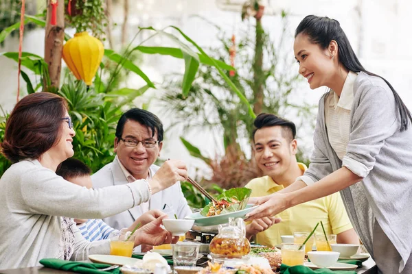 Genç Güzel Asyalı Kadın Aile Yemeğinde Misafirlere Lezzetli Salata Ikram — Stok fotoğraf
