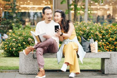 Güzel genç Çinli bir kadın bankta otururken sosyal medyada erkek arkadaşına ilginç mesajlar yolluyor.