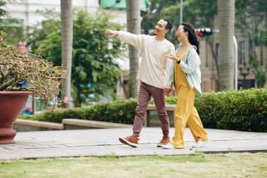 Genç Asyalı çift birlikte vakit geçirmeyi seviyor, sokakta yürüyor ve ilginç şeyleri tartışıyorlar.
