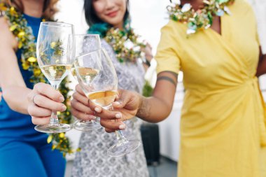 Close-up image of Christmas party guests toasting with glasses of champagne clipart