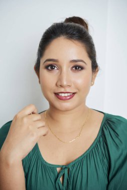Kameraya gülümseyen yeşil bluzlu güzel Vietnamlı kadının portresi.