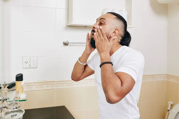 Hombre Barbudo Guapo Pie Frente Espejo Baño Aplicando Loción Antiarrugas — Foto de Stock