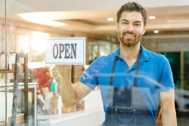 Kafesinin ya da dükkanının cam duvarına kot önlüklü mutlu baristanın portresi asılıydı.