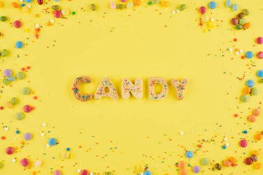 Şekerli kurabiyelerden yapılmış ve parlak sarı arka planda küçük parçacıklar serpiştirilmiş şeker.