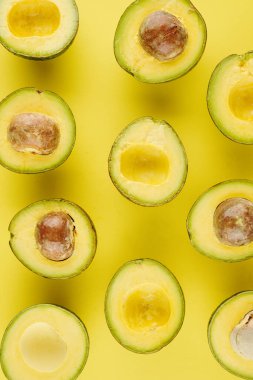 Sarı yüzeyde çekirdekleri olsun ya da olmasın taze kesilmiş olgun avokadolar.