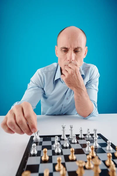 Fronsen Pensive Volwassen Man Making Move Met Schaken Stuk Geïsoleerd — Stockfoto