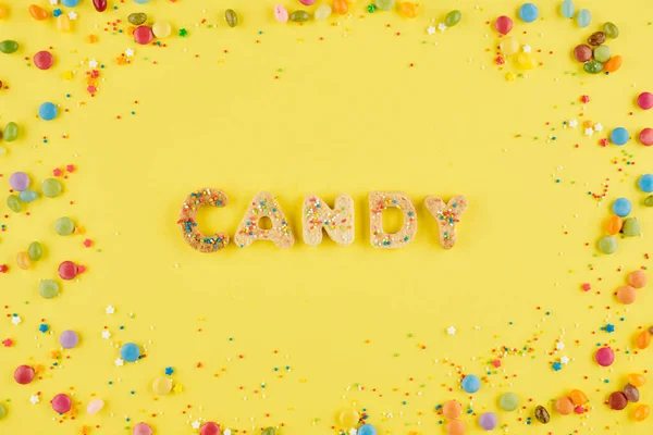 砂糖クッキーで作られ 明るい黄色の背景に小さなスプリンクルで飾られた単語キャンディー — ストック写真
