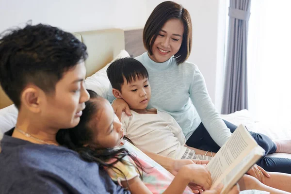 Aziatisch Gezin Met Twee Kinderen Rusten Bed Vader Lezen Interessant — Stockfoto