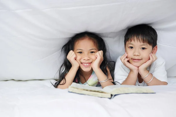Šťastný Malý Bratr Sestra Odpočívají Pod Přikrývkou Otevřenou Knihou Dívají — Stock fotografie