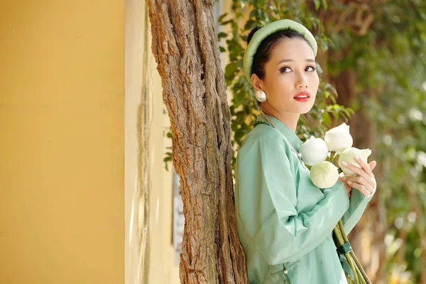 身穿欧代服装的年轻貌美的越南女子的画像 她手持白莲花 望着远方 — 图库照片