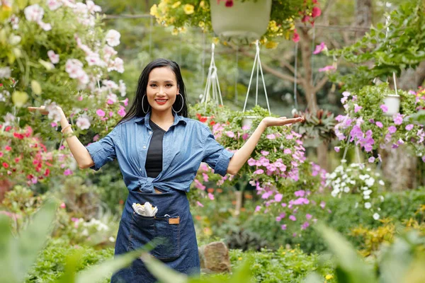 漂亮的年轻亚洲女人 穿着牛仔和围裙 欢迎顾客来到她的花圃 — 图库照片