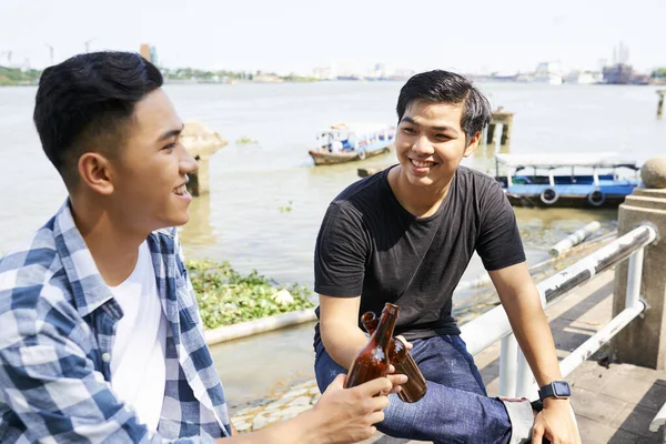 Två Asiatiska Vänner Sitter Utomhus Nära Sjön Och Dricker Tillsammans — Stockfoto