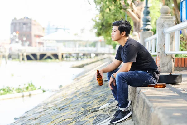Ασιάτης Νεαρός Πίνει Μπύρα Και Βλέπει Ποτάμι Απολαμβάνοντας Σαββατοκύριακα Έξω — Φωτογραφία Αρχείου