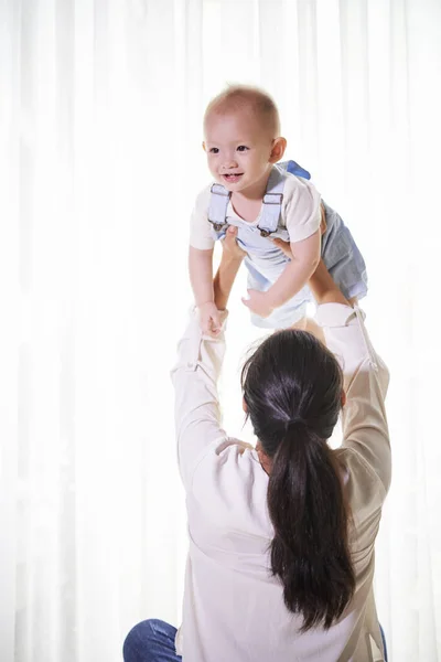 Mãe Levantando Seu Bebezinho Sorridente Quando Brincava Com Ele Casa — Fotografia de Stock