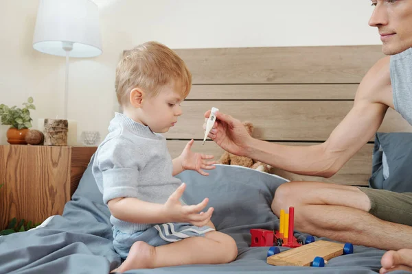 Padre Misura Temperatura Suo Piccolo Figlio Mentre Giocano Sul Letto — Foto Stock