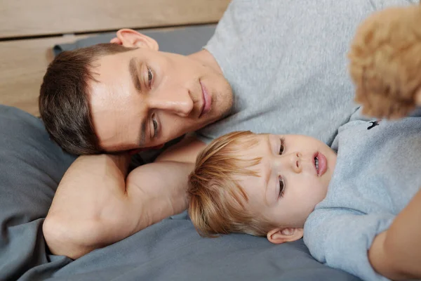 Giovane Padre Sdraiato Sul Letto Riposare Insieme Suo Piccolo Figlio — Foto Stock