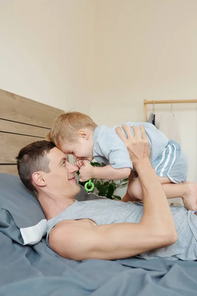 Mutlu Bir Baba Bir Yaşındaki Oğlu Evde Yatakta Oynuyorlar — Stok fotoğraf