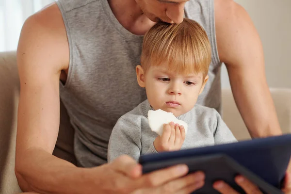 Mały Chłopiec Ogląda Kreskówki Tablecie Cyfrowym Siedząc Razem Ojcem — Zdjęcie stockowe
