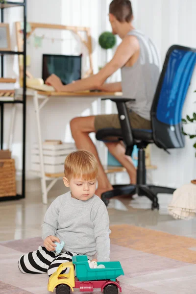 Niño Jugando Con Juguetes Con Padre Trabajando Computadora Fondo Casa — Foto de Stock