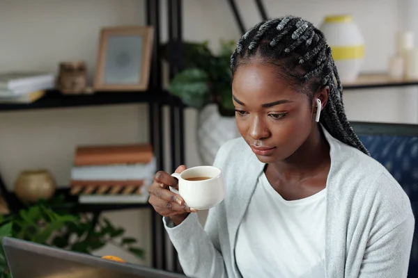 非常严肃的年轻黑人女商人早上喝咖啡 在笔记本电脑屏幕上读电子邮件 — 图库照片