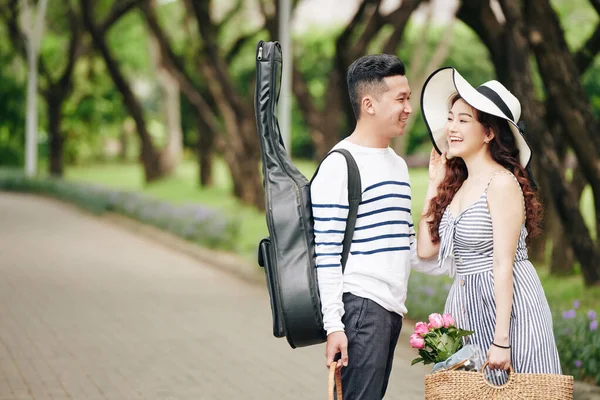 年轻英俊的吉他手站在公园里笑着看着漂亮的女朋友 — 图库照片