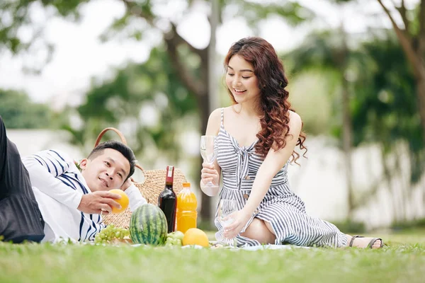 快乐的一对年轻的亚洲夫妇在公园野餐时喜欢喝酒和吃水果 — 图库照片